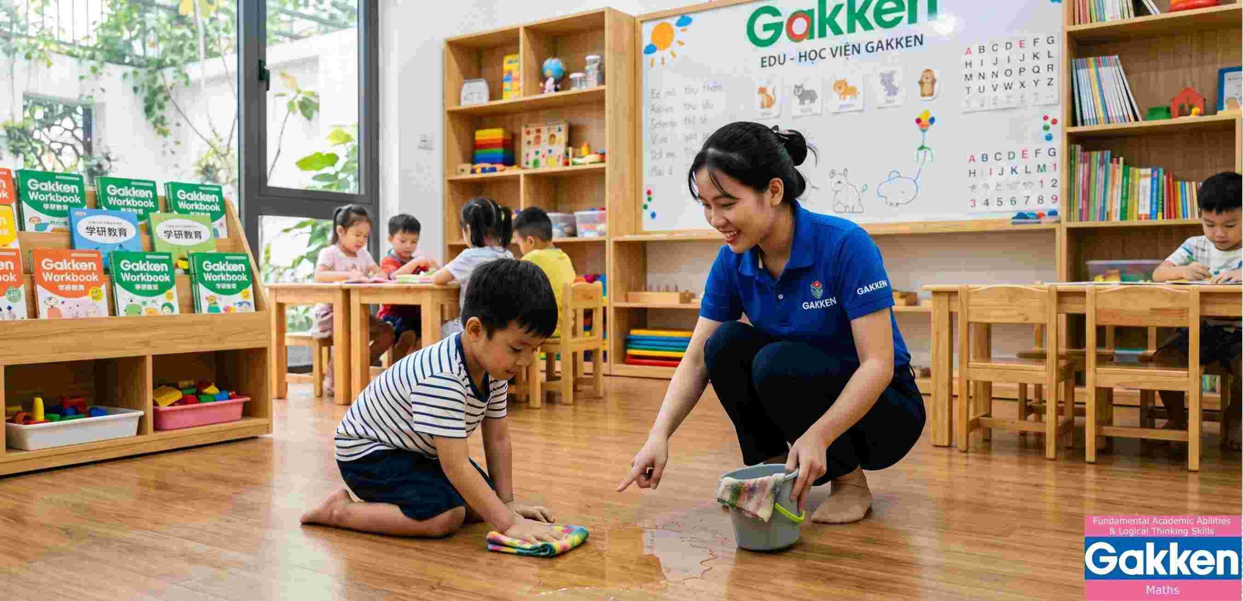 Dạy con kiểu Nhật cùng Gakken thông qua trò chơi giáo dục giúp trẻ tự lau nước đổ trên sàn, rèn luyện tính tự lập, tinh thần trách nhiệm và kỹ năng tự phục vụ trong lớp học.